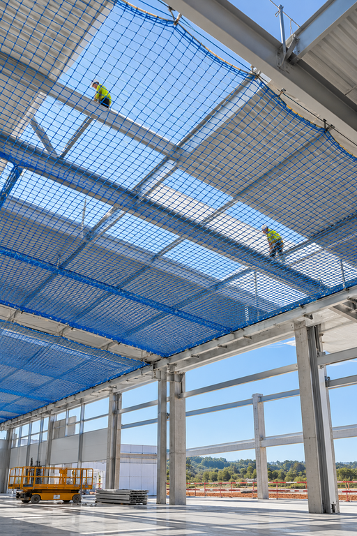 Construcción industrial con red de seguridad azul